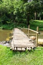 Old wooden bridge over the stream with green lawn Royalty Free Stock Photo