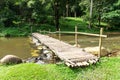 Old wooden bridge over the stream with green lawn Royalty Free Stock Photo