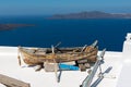 Old wooden broken boat on roof of house, located at Santorini island, Greece Royalty Free Stock Photo