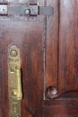 Old wooden brown door with a bolt and a bronze handle