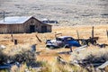 Old wooden building in ghost town and car remains