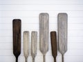Old wooden canoe paddles on white wood plank wall background. Royalty Free Stock Photo