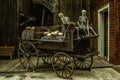 Old wooden carriage with skeletons and pumpkins on it in a building Royalty Free Stock Photo