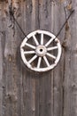 An old wooden carriage wheel hanging on the barn wall Royalty Free Stock Photo