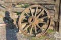 An old wooden carriage wheel near the barn. Close up Royalty Free Stock Photo