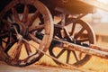 An old wooden cart with big wheels stands on the road in the village on an autumn sunny day. Agriculture. The peasantry.