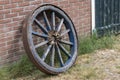 Old wooden cart wheel against a brick wall Royalty Free Stock Photo