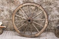 An old wooden cart wheel against a stone fence Royalty Free Stock Photo