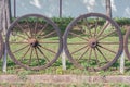 Old wooden cartwheel is fence for farm.