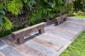 Old wooden chair in garden. Wood bench made from log. Bench made of a single piece of wood on a metal suppor Royalty Free Stock Photo
