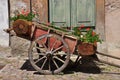 Old wooden chariot with red geraniums