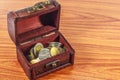 Old wooden chest with golden coins isolated on white background.