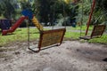 Old wooden children swing on iron chains