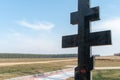 An old wooden Christian cross against a clear blue sky on a beautiful summer day. A statuette of Jesus in the center of the cross Royalty Free Stock Photo