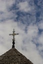 old wooden church against the blue sky in Ukraine, wooden roof with a cross Royalty Free Stock Photo