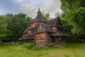 Old wooden church among dense foliage in the open-air museum Pirogovo