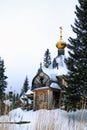 Old wooden church with golden dome and cross in winter day Royalty Free Stock Photo