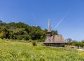 Old wooden church in a green meadow near a cemetery and forest in a rural landscape in Maramures