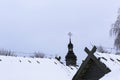 Old wooden church made of round logs. Cross on the dome. Winter Russian land scape. Snow covered trees. Royalty Free Stock Photo