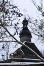 Old wooden church made of round logs. Cross on the dome. Winter Russian land scape. Snow covered trees. Royalty Free Stock Photo