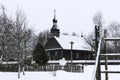 Old wooden church made of round logs. Cross on the dome. Winter Russian land scape. Snow covered trees. Royalty Free Stock Photo