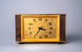 Old wooden clock with with dial in yellow frame and black hands and numbers. Brown vintage watch with wooden case on Royalty Free Stock Photo