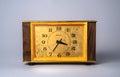 Old wooden clock with with dial in yellow frame and black hands and numbers. Brown vintage watch from USSR with wooden