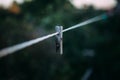 Old wooden clothespegs hanging on rope.