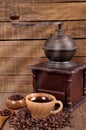 Old wooden coffee grinder and roasted coffee beans on a wooden table . Fresh hot coffee in Cup Royalty Free Stock Photo