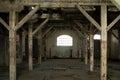 Old wooden columns. Old abandoned warehouse, illuminated by light from the window