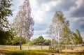 Old wooden corral against a cloudy sky. Grass paddock on farmland with wooden fence Royalty Free Stock Photo