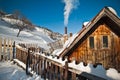 Old wooden cottage with hill covered by snow in background. Bright cold winter day in the mountains landscape.Carpathian mountains Royalty Free Stock Photo