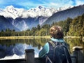 A tourist looking on a highest mountain in New Zealand reflecting in the waters of lake Matheson Royalty Free Stock Photo