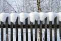 Old wooden country fence covered with a thick layer of a white fluffy snow in winter Royalty Free Stock Photo
