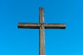 An old wooden cross against a clear blue sky. The crucified Jesus on the cross. The concept of the pure and unrequited love of God Royalty Free Stock Photo