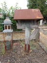 Old wooden cross with an iron grave lamp