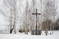 Old wooden cross in a small park of birches in winter Royalty Free Stock Photo