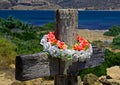 Wooden cross with wreath in background of coast