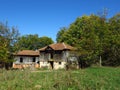 Old wooden decrepit shabby house in need of repair with damaged roof, walls, doors,  and broken windows. Sepis colour. Royalty Free Stock Photo