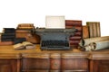 Desk with vintage typewriter holding an empty sheet of paper and ancient books and maps Royalty Free Stock Photo