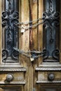 Old wooden door of an abandoned house is locked. Chain on the vintage door of a closed mansion Royalty Free Stock Photo