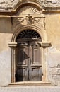 Old wooden door archway aged front entrance of medieval building decorated with stone on stucco background Royalty Free Stock Photo