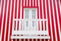 Old wooden door and a balcony on the background of the striped red and white wall. Portugal Windows. The exterior of Royalty Free Stock Photo