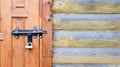 Old wooden door with a black metal bolt. Close up view of a lock and latch on a wooden door. Rustic wooden metal door latch. This Royalty Free Stock Photo