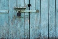 Old wooden door with blue painted planks closed with a padlock. Grunge background Royalty Free Stock Photo