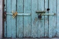 Old wooden door with blue painted planks closed with a padlock. Grunge background Royalty Free Stock Photo