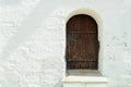Old wooden door with a bolt in the white stone wall Royalty Free Stock Photo