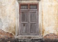 Old wooden door in broken dirty wall.