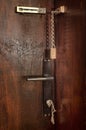 Old Wooden Door with Chain Lock, key in a keyhole and a door knob handle Royalty Free Stock Photo