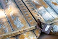 Old wooden door closed with a rusty metal pad. Close up Royalty Free Stock Photo